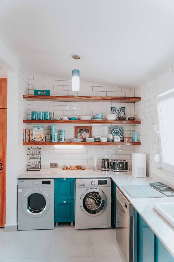 services-01 A bright modern kitchen featuring open shelving and integrated washing appliances.