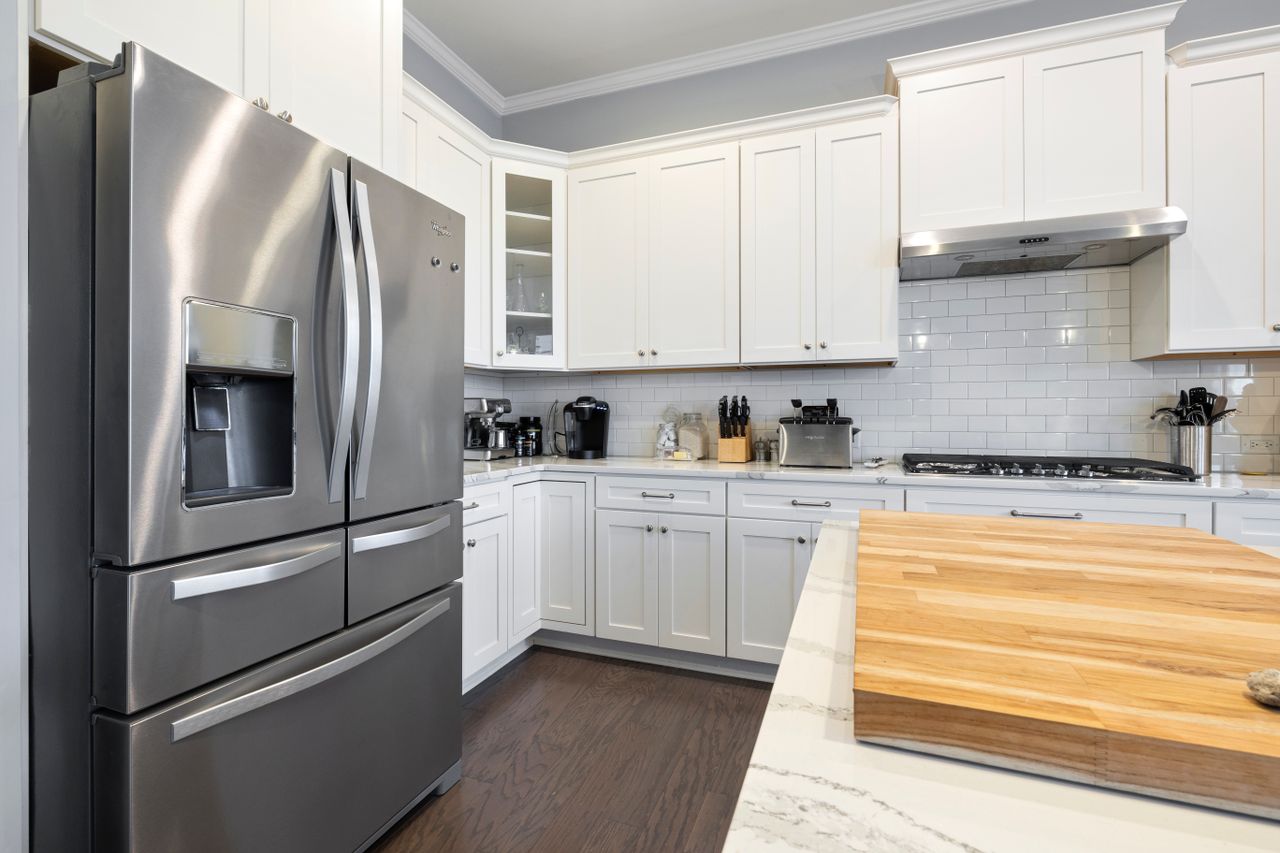 about-02 Spacious modern kitchen featuring stainless steel appliances and white cabinets, perfect for culinary enthusiasts.